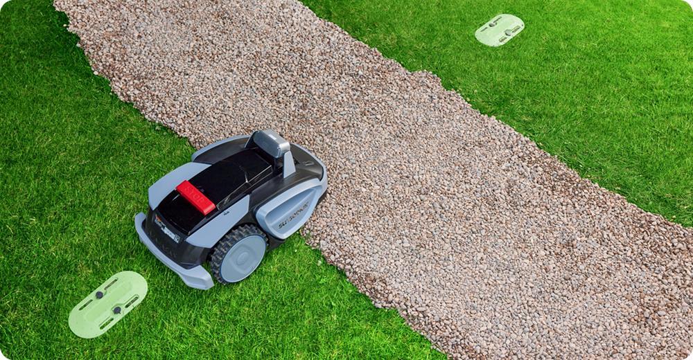 Robot tondeuse naviguant entre deux zones de pelouse sans câble périphérique